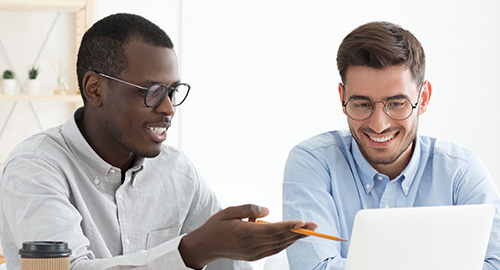 Two federal employees discuss a work project while having coffee